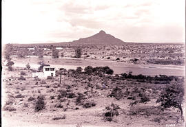 South-West Africa. Railway line crossing river with prominent koppie in the distance.