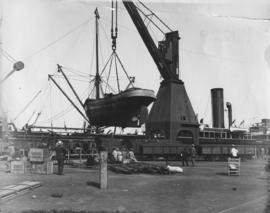 The 'Caledonia' being lifted by crane in dock yard.