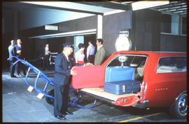 Johannesburg, 1973. Porter loading suitcases into Chrysler Valiant station wagon at Park Station....