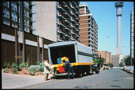 
Loading suitcases from SAR truck in city street.
