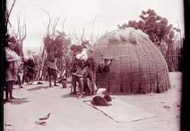 Swaziland, 1933. Swazi men preparing for the dance outside a hut.