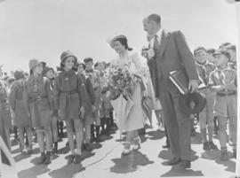 
Queen Elizabeth walks between girl and boy scouts.

