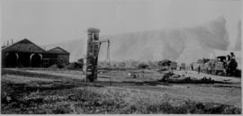 Graaff-Reinet, 1895. Water column with steam train and locomotive shed in the distance. (EH Short)