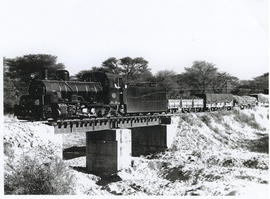 South-West Africa, 1957. SAR Class NG15 with goods train on bridge over small river on Kalkfeld -...