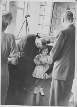 Kimberley, 18 March 1947. Little girl being coached in presenting a gift to Princess Elizabeth at...