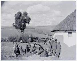 "Eshowe district, 1956. Zulus in blankets next to hut."