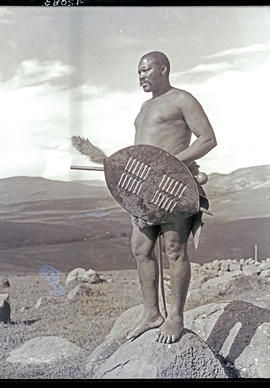 Zululand, 1933. Zulu warrior standing on rock.