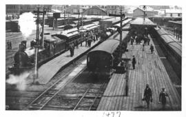 Cape Town, 1893. Station platforms with a mainline train ready to depart behind a CGR 6th Class o...