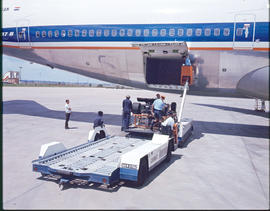 SAA Boeing 747 ZS-SAN 'Lebombo' with baggage cart on apron. Note racing car on the lift.