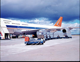 SAA Boeing 747 ZS-SAN with baggage carts on apron.
