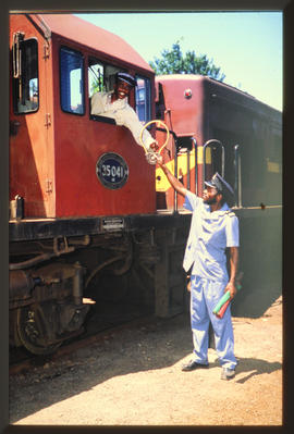 
SAR driver of SAR Class 35-000 No 35-041 receiving tablet at railway station.
