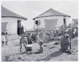 "Eshowe district, 1956.Zulu group next to huts at Nkandla forest."