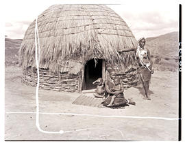 Natal, 1946. Two Zulu women with babies in front of hut.
