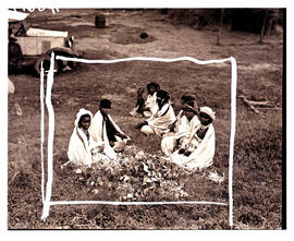 Transkei, 1940. Group of women with baby sitting on grass.
