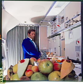 SAA Boeing 747 interior, steward arranging food in galley.