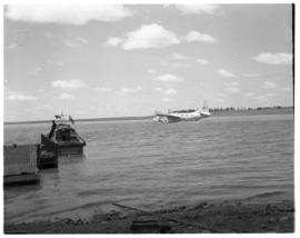 Vaal Dam, circa 1949. Arrival of BOAC flying boat Solent G-AKNS. Luggage boat with aircraft in th...