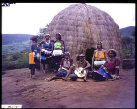 Zulus at traditional hut.