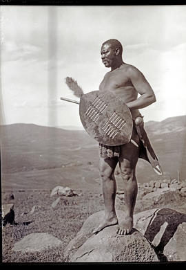 Zululand, 1933. Zulu warrior standing on rock.