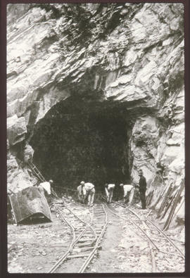 Labourerrs clearing debris from tunnel entrance.