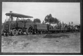 Dutton roadrail tractor hauling train with standing passengers.