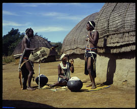 Zululand, 1961. Man and women at traditional huts.