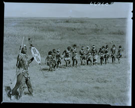 Zululand, 1957. Zulu warrior with group of dancing women.