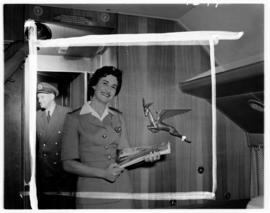 February 1958. SAA Douglas DC-7B interior. Hostess. Note Flying Springbok emblem.