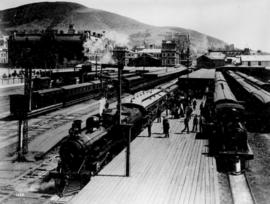 Cape Town. Steam locomotives at station showing a mainline train on the left behind CGR 4th Class...