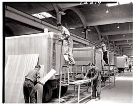 "Johannesburg, 1962. Sheetmetal workers fitting cladding on trailers in Road Transport Servi...