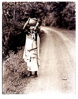 Transkei, 1940. Woman carrying pot on head.