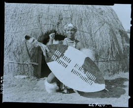 Zululand, 1957. Zulu warrior in front of hut.