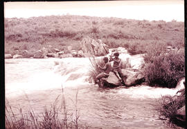 Swaziland, 1933. Two Swazi women hairdressing beside a stream.