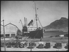 Cape Town. Row of old cars with ship in Table Bay harbour.