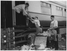 
Train staff loading bottles from crate into train.

