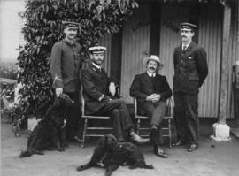 Blockhill, circa 1910. Four men and two dogs posing at station luggage room. Mr John Blain Robert...