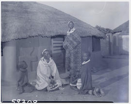 Pretoria district, 1952. Ndebele women and children in front of hut.