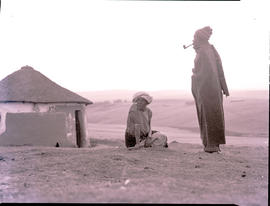 "Transkei, 1954. Man and woman at hut."
