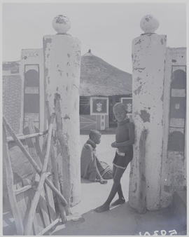 Pretoria district, 1952. Ndebele kraal, young boy leaning on wall.