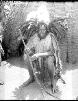 Swaziland, 1933. A Swazi induna in full regalia in front of hut.
