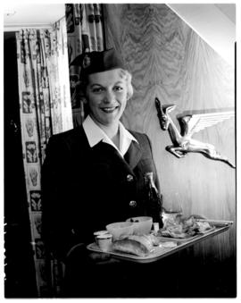 21 April 1956. Departure of first SAA DC-7B for London. ZS-DKD. Interior. Hostess with tray of fo...