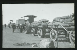 Convoy of tractors and trailers in desert. Tractor closest to camera is a Saunderson.