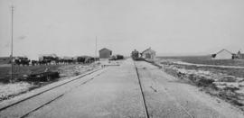 Houtkraal, 1895. Cape 3rd Class on train with station and inspanned oxen in the distance, looking...