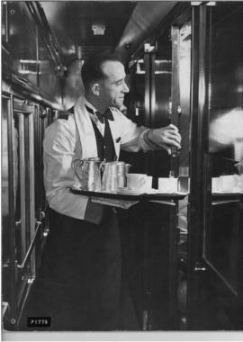 Railway steward with morning coffee at door of passenger compartment.