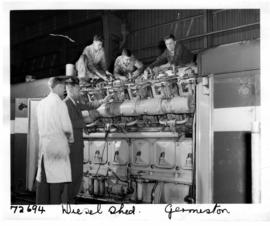 Germiston, 1963. Mechanics working on train engine in diesel shed.