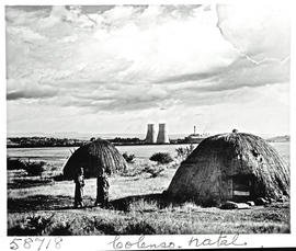 "Colenso, 1951. Traditional huts with power station in the distance."
