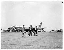 
SAA Boeing 707 ZS-CKD 'Cape Town'. Passengers walking away. Note Trek Airways Lockheed L1649A St...