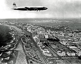 Durban, 1963. Louis Botha airport. SAA Douglas DC-7B ZS-DKF 'Good Hope' over Durban beach. Possib...