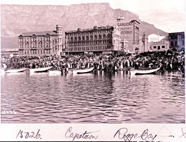Cape Town. Large crowd on beach with small boats at Rogge Bay.