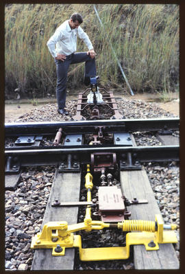 Man standing at railway track switch.