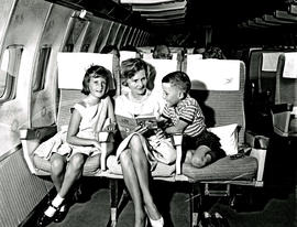 
SAA Boeing 707 interior. Cabin service. Mother and young girl and boy.
